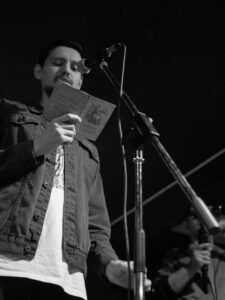 Black and white photo of a singer performing on stage with a microphone