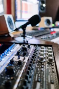 Close-up of a recording studio mixing console with faders and monitors