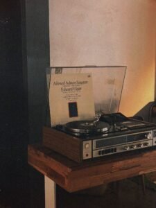 Vintage record player spinning a vinyl LP in a warm, dim room